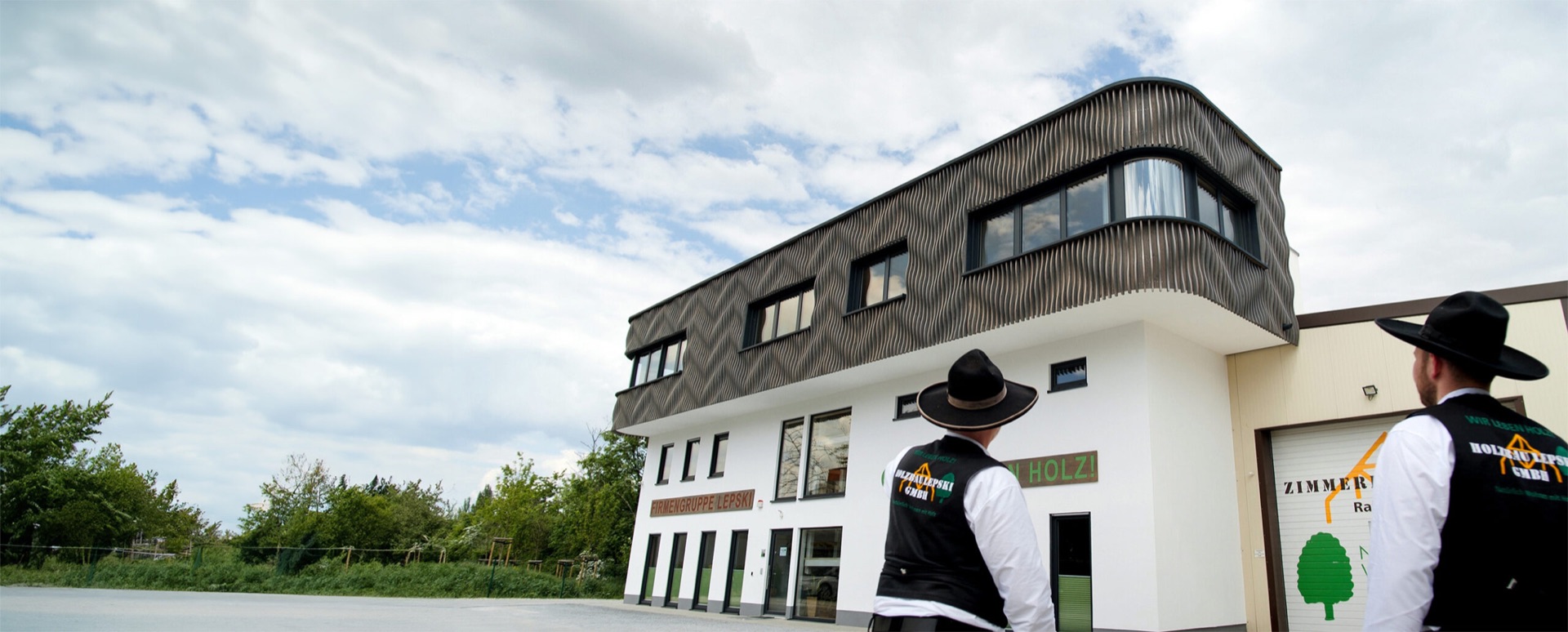 Zwei Zimmerer in Kluft vor dem Firmengebäude der Holzbau Lepski GmbH in Dresden-Reick