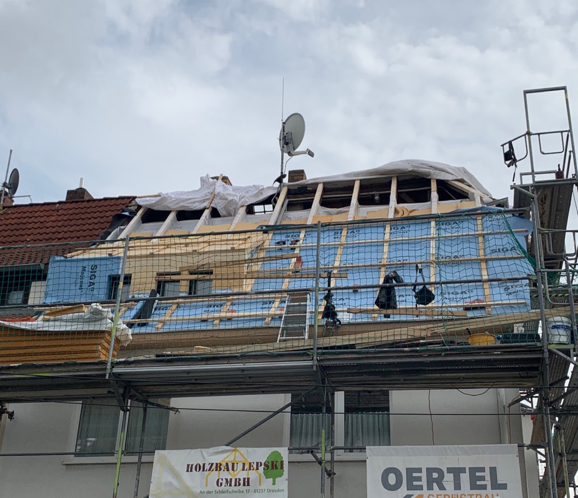 Dachsanierung an einem Dresdner Wohnhaus: Gerüst, neue Unterdeckung und Lattung, Bauschild der Holzbau Lepski GmbH