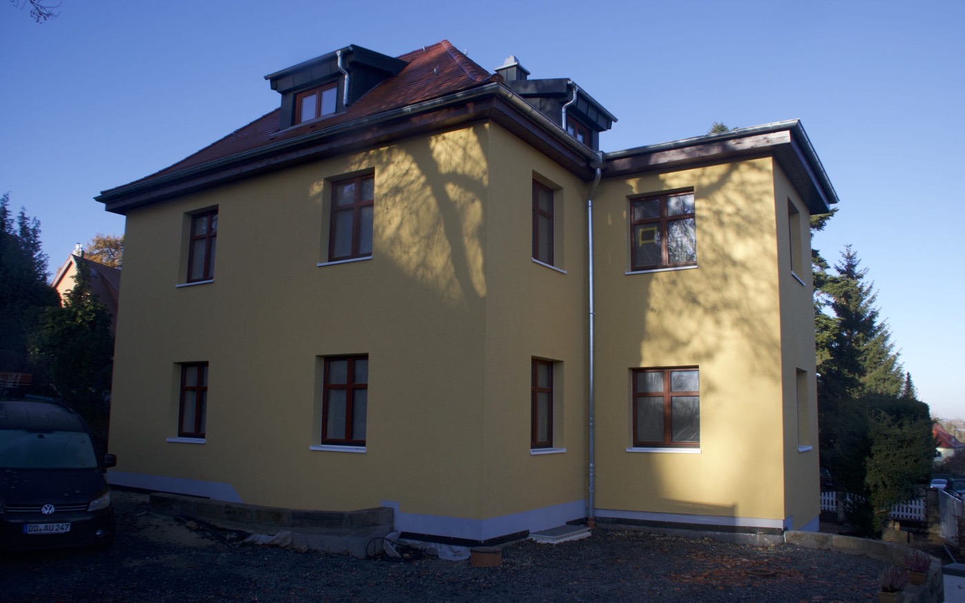 Einfamilienhaus in Dresden mit neu gedämmter, gelb verputzter Fassade und Walmdach