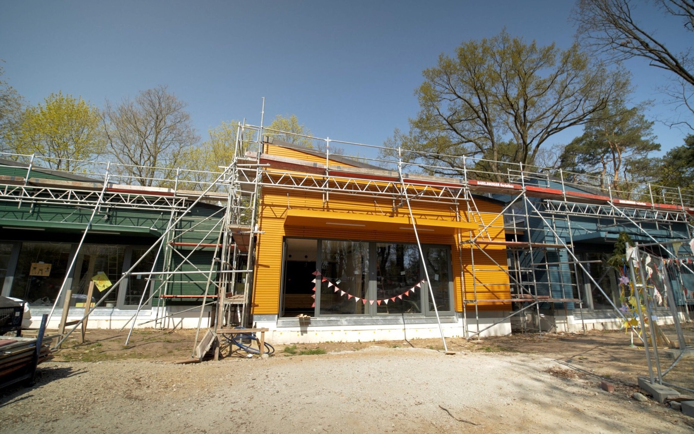 Erweiterungsbau der Kita in Teltow in Holzbauweise mit farbiger Holzfassade während der Bauphase