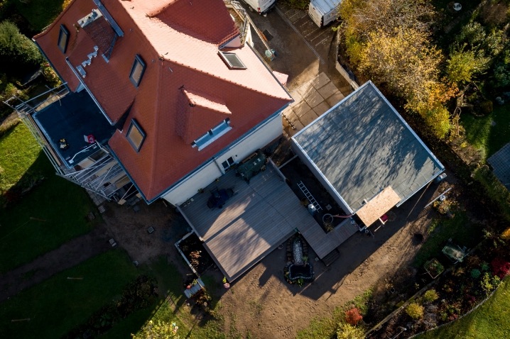 Saniertes Mehrfamilienhaus in Dresden von oben: große Holzterrasse im Garten, daneben die Garage