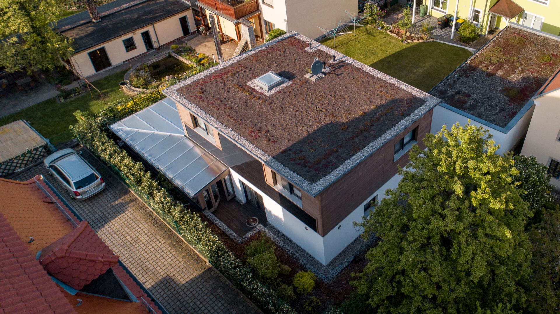 Musterhaus „Felix“ in Dresden schräg von oben: Holzhaus mit begrüntem Flachdach und Garten