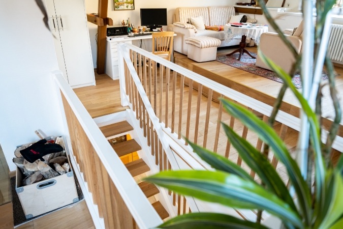 Holztreppe mit Holzgeländer zur Galerie im umgebauten Wohnhaus