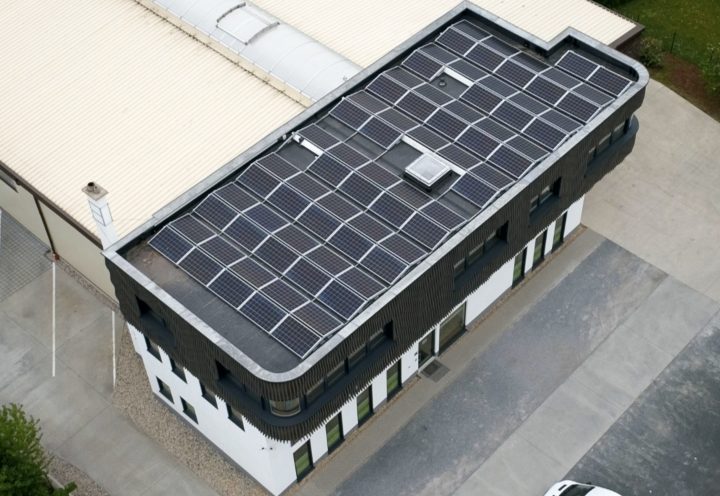 Firmengebäude in Dresden-Reick von oben: Flachdach mit Photovoltaikanlage, daneben das Hallendach