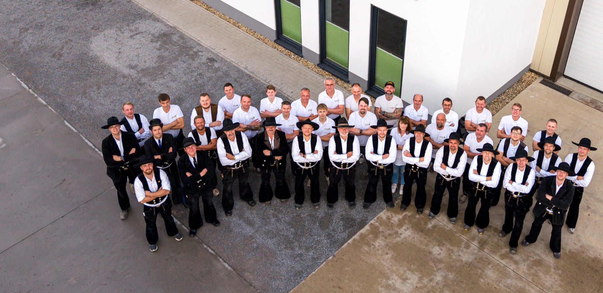 Das Team der Holzbau Lepski GmbH vor dem Firmengebäude in Dresden-Reick, vorn Zimmerer in Kluft